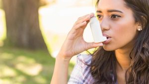 Pretty brunette using inhaler